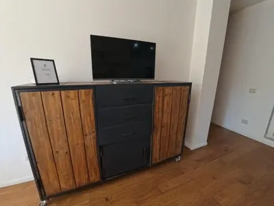 a entertainment center with a television and a laptop on it at Benny's House Rome in Rome
