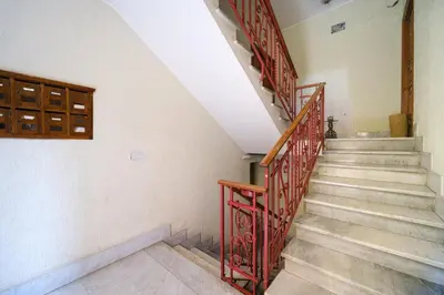 a staircase in a house with red metal railing at Terrazza Monteverde by BuddyRent in Rome