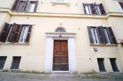 a building with a wooden door and windows at Terrazza Monteverde by BuddyRent in Rome