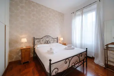 a bedroom with a bed with white sheets and a window at Terrazza Monteverde by BuddyRent in Rome