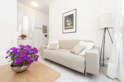 a living room with a couch and a table with purple flowers at Foscolo al 24 in Rome