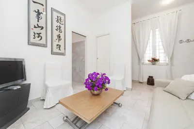 a living room with a vase of purple flowers on a table at Foscolo al 24 in Rome
