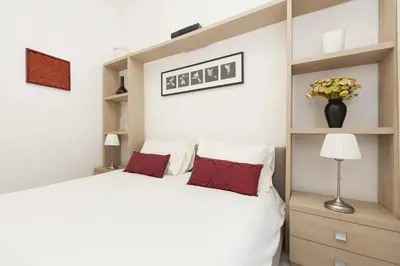 a bedroom with a large white bed with red pillows at Foscolo al 24 in Rome