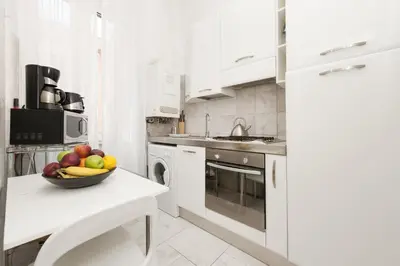 a white kitchen with a bowl of fruit on a table at Foscolo al 24 in Rome