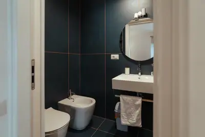 a bathroom with a toilet and a sink and a mirror at Marino's Apartment in Rome