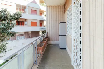 an empty corridor of a building with a refrigerator on a balcony at Marino's Apartment in Rome