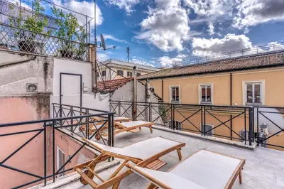 an apartment patio with chairs and a balcony at Maison Della Vite in Rome