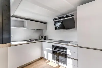 a kitchen with white cabinets and a sink and a microwave at Maison Della Vite in Rome