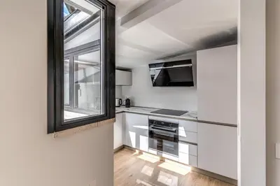 a kitchen with white cabinets and a window at Maison Della Vite in Rome