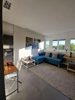 a living room with a blue couch and a table at La casetta del villaggio - Cozy apartment in Flaminio in Rome
