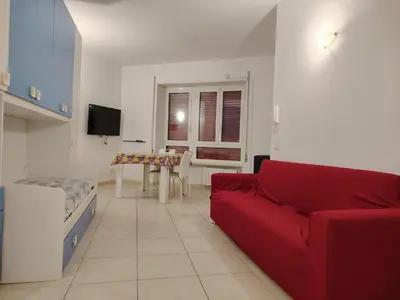 a living room with a red couch and a table at Regina di Cuori in Rome