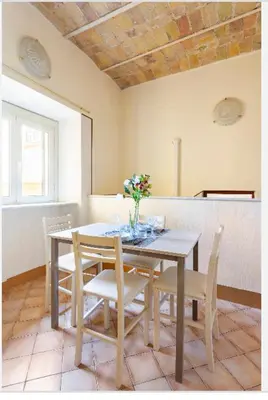 a dining room table with chairs and a vase of flowers on it at Appartamento Roma centro 2 da 2 a 4 posti 