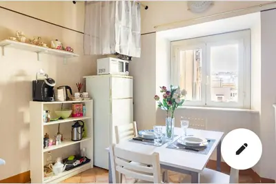 a kitchen with a table with chairs and a window at Appartamento Roma centro 2 da 2 a 4 posti 