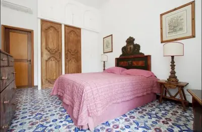 a bedroom with a pink bed in a room at Domus Antonella a Trastevere in Rome