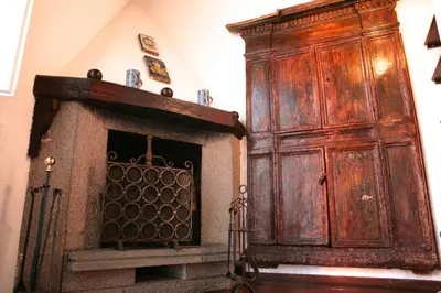 a large wooden cabinet in a room with a fireplace at Domus Antonella a Trastevere in Rome