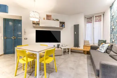 a living room with a table and yellow chairs at Loves Home in Rome