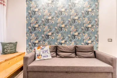 a couch in a living room with a floral wallpaper at Loves Home in Rome
