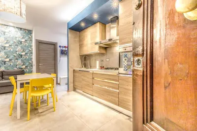 a kitchen with yellow chairs and a table in a room at Loves Home in Rome