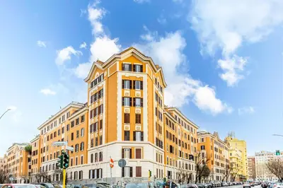 a tall yellow building on a city street with cars at Loves Home in Rome