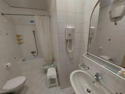 a bathroom with a sink and a toilet and a mirror at Hotel Positano 2 MIMOSA in Rome