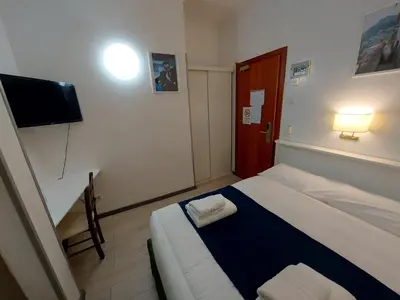 a small room with a bed and a flat screen tv at Hotel Positano 2 MIMOSA in Rome