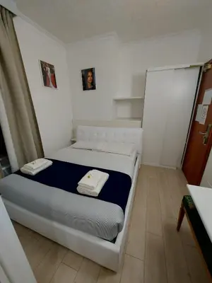 a bedroom with a white bed with two towels on it at Hotel Positano 2 MIMOSA in Rome