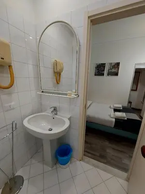 a bathroom with a sink and a mirror and a bed at Hotel Positano 2 MIMOSA in Rome