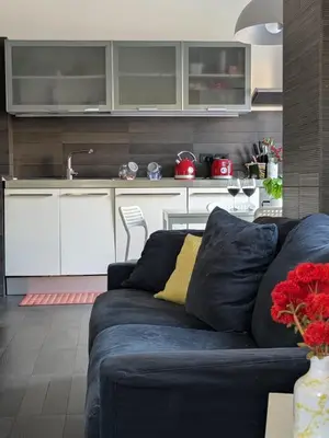 a living room with a blue couch and a kitchen at Interno7 in Rome