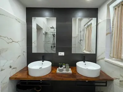 two sinks in a bathroom with two mirrors at Il giardinetto di Ponte Milvio in Rome