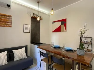 a dining room with a table and a couch at Il giardinetto di Ponte Milvio in Rome
