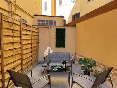 a patio with a table and chairs and a fence at Il giardinetto di Ponte Milvio in Rome