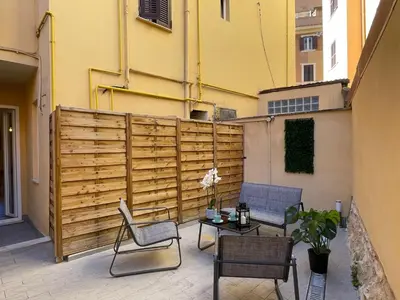 a patio with two chairs and a table and a fence at Il giardinetto di Ponte Milvio in Rome