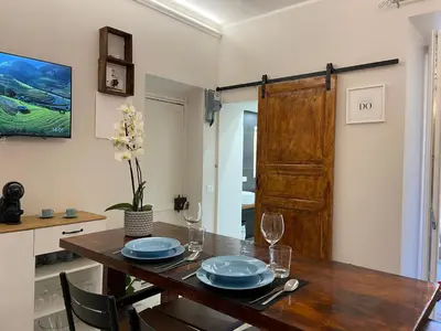 a dining room with a wooden table with plates and wine glasses at Il giardinetto di Ponte Milvio in Rome