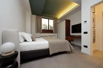 a bedroom with a bed and a desk and a television at Crispi Loft - My Extra Home in Rome