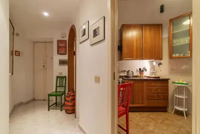 a kitchen with wooden cabinets and red chairs at GuestHost - Pretty Apartment near Musei Vaticani in Rome