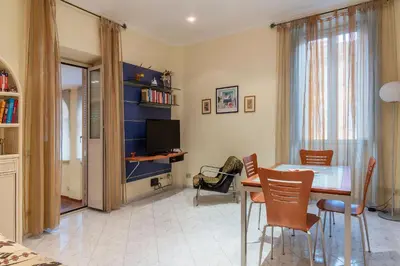 a living room with a dining room table and chairs at GuestHost - Pretty Apartment near Musei Vaticani in Rome