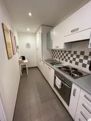 a kitchen with white cabinets and a stove top oven at Lovely Apartment at Saint Peter's Square Vatican in Rome