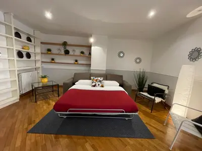 a bedroom with a large bed with a red blanket at Lovely Apartment at Saint Peter's Square Vatican in Rome