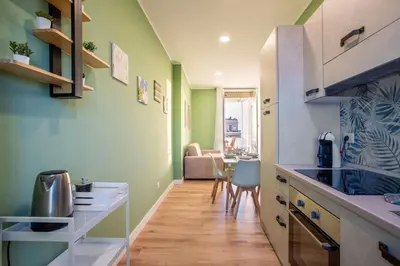 a kitchen with green walls and a table with chairs at Penthouse Lux with Panoramic View in Rome