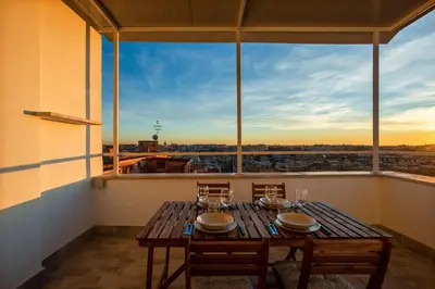 a table on a balcony with a view of a city at Penthouse Lux with Panoramic View in Rome