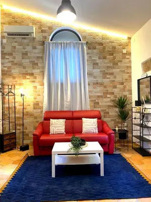 a living room with a red couch and a table at Dimora Ardeatina in Rome