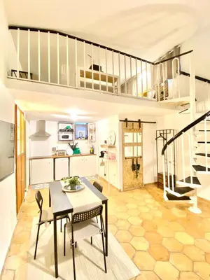 a living room with a table and chairs and a staircase at Dimora Ardeatina in Rome