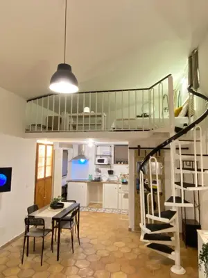 a living room with a table and chairs and a kitchen at Dimora Ardeatina in Rome