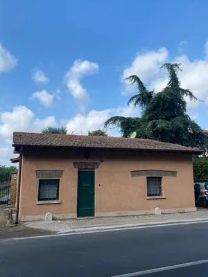 a small building with a green door on the side of a street at Dimora Ardeatina in Rome