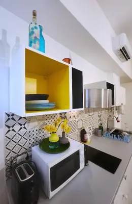 a kitchen with a microwave and flowers on a counter at Sanpietrino Home in Rome