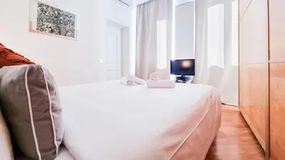a white bedroom with a bed and a television at Luxury Penthouse with Terrace by Spanish Steps in Rome