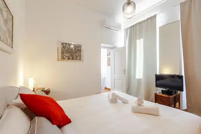 a living room with a white couch and a television at Luxury Penthouse with Terrace by Spanish Steps in Rome