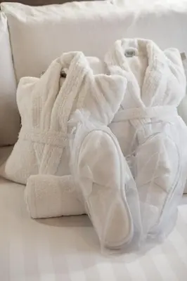 a pile of white towels sitting on a couch at Elegantia Luxury Rooms Trastevere in Rome