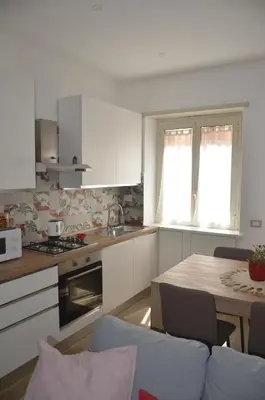 a kitchen with white cabinets and a table with a table at 50 al Vaticano House in Rome