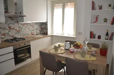 a kitchen with a wooden table with chairs and a tableasteryasteryasteryasteryastery at 50 al Vaticano House in Rome